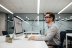 Person wearing FL-41 overfit glasses working at a bright office desk